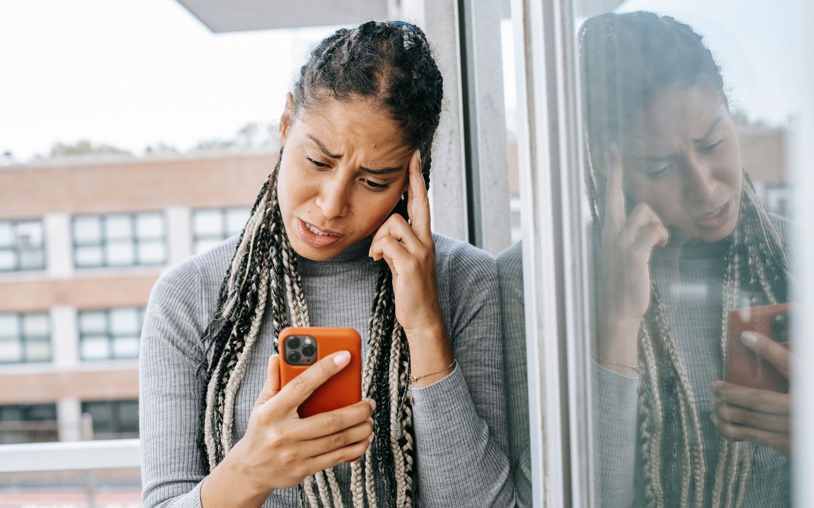 Mulher olhando uma mensagem no celular com expressão de dúvida