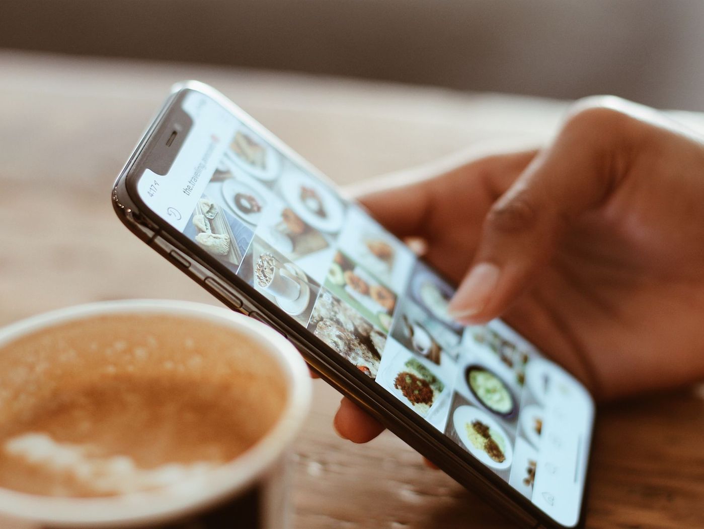 Mão rolando o feed do Instagram no celular